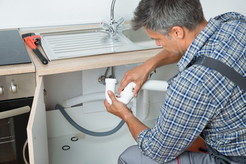A man checking the fixtures to avoid low water pressure